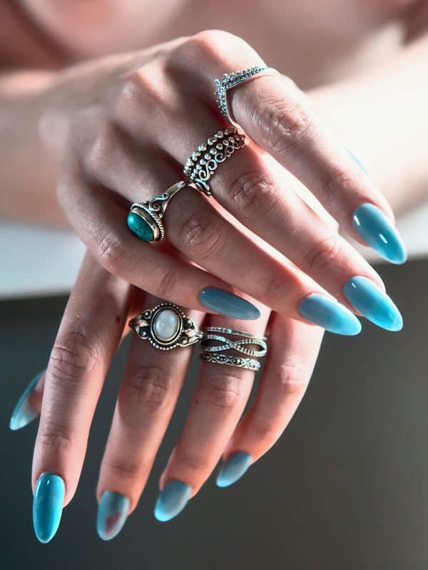 Long blue almond nails with silver rings